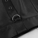 Close-up of a black jacket with a button and strap detail on a light gray background