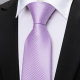 Close-up of a lavender tie on a white shirt with a black suit jacket.