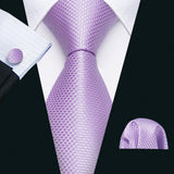 Purple tie set with matching cufflinks and pocket square on a black background