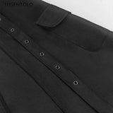 Close-up of a black shirt with button details on a white background
