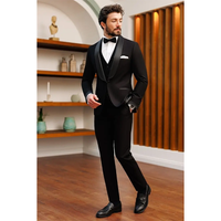 A man in a black tuxedo with a bow tie stands confidently on a wooden floor. He looks to the side with his hand in his pocket, exuding elegance.