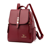 A stylish burgundy backpack with a fold-over flap, gold hardware, and zippers, featuring a kangaroo logo on the front.