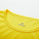 Close-up of a vibrant yellow polyester shirt collar, displaying size 'M' and fabric composition details.