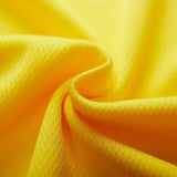 Close-up of vibrant yellow fabric, showcasing its soft, textured surface and gentle folds.
