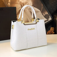 Elegant white handbag with crocodile texture, featuring gold hardware and "Menglutha" logo, set against a stylish background.