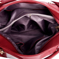 Inside view of a red leather handbag with a purple lining and multiple compartments, including a zippered pocket.