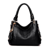 Stylish black leather handbag with gold accents and a decorative tassel, featuring dual handles for versatility.