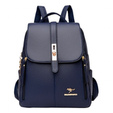 Stylish navy blue backpack with a gold clasp and zipper accents, featuring dual straps and a logo emblem on the lower front.