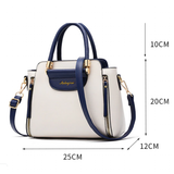 Stylish two-tone handbag in cream and navy, featuring gold accents and dimensions of 25x20x12 cm, with both handles and shoulder strap.