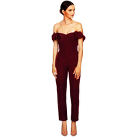 Elegant woman in a maroon off-shoulder jumpsuit, standing gracefully. Her hair is neatly tied back, and she wears nude heels. Minimalist and poised.