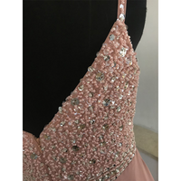 Close-up of a pink dress bodice adorned with sequins and beads on a black mannequin. The embellishments create an elegant, sparkly texture.