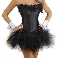 A woman wearing a strapless black corset with lace details, a black tulle tutu skirt, and white cuffs. The outfit conveys a playful and stylish tone.