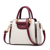 A stylish two-tone white and burgundy handbag with gold accents and a detachable shoulder strap. Elegant and modern design.