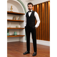 A man in formal attire, wearing a black vest, white shirt, and bow tie, stands confidently in a stylish room with wooden flooring and shelves.