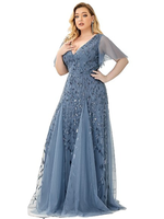 A woman in an elegant, blue lace gown with sheer sleeves and floral embroidery, set against a white background, conveys a sense of grace and style.
