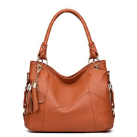 A stylish brown leather handbag with a slouchy design, featuring gold hardware and a decorative tassel charm.