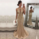 Woman wearing gold evening gown. The dress has a keyhole neckline and a mermaid silhouette, conveying elegance.
