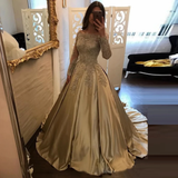 A woman poses in a luxurious, golden satin ball gown with intricate lace detailing. She stands in front of an ornate mirror, exuding elegance.