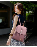 A woman stands gracefully outdoors, wearing a navy top and a floral skirt, carrying a stylish pink backpack.