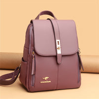 Stylish purple backpack with a flap closure and gold accents, featuring side pockets and a logo, set against a warm background.