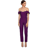 Woman in a purple off-shoulder jumpsuit with ruffled sleeves and nude heels. She stands confidently against a white background, creating an elegant tone.