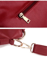 Close-up of a textured red clutch bag featuring a gold zipper and a gold clasp for attaching a strap.