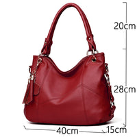 A stylish red leather handbag with a textured finish, featuring two handles and a decorative tassel. Dimensions: 40x28x15 cm.