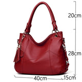 A stylish red leather handbag with a textured finish, featuring two handles and a decorative tassel. Dimensions: 40x28x15 cm.