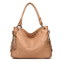 A stylish tan leather handbag with a textured finish, gold hardware, and a decorative tassel.