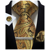 Gold and black paisley tie set with matching pocket square and cufflinks on a white background.