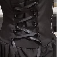 Close-up of a black corset back, featuring crisscrossed satin ribbons in a glossy finish. The fabric appears smooth, conveying elegance and sophistication.