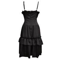 Elegant black dress with thin straps and a ruffled neckline. The fitted bodice flows into a two-tiered layered skirt, conveying a classic, sophisticated tone.
