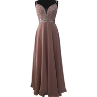 Elegant evening gown with a beaded, sparkling bodice and deep V-neckline. Flows into a full-length, soft pink skirt, conveying a glamorous tone.