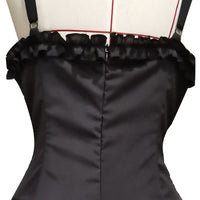 Close-up of a black satin dress with thin straps and a ruffled top edge. The dress has vertical seams and is displayed on a mannequin, suggesting elegance.