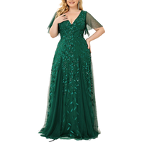 A woman in a flowing emerald green evening gown with leaf patterns and short sleeves poses against a white background, conveying elegance and grace.