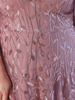 Close-up of a mauve dress with intricate sequin embroidery in leafy patterns, conveying elegance and detailed craftsmanship.