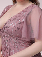A close-up of a woman in a mauve gown with floral sequined patterns. The dress features sheer flutter sleeves, creating an elegant and feminine look.