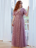 A woman wearing an elegant mauve gown with leaf patterns. She appears serene and content, with natural light filtering in.