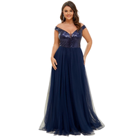 Woman in elegant navy gown with sequined bodice and off-the-shoulder design. The flowing skirt adds a graceful touch. She smiles confidently.