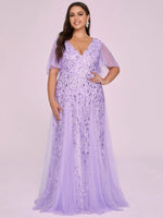 woman in a flowy lavender gown with delicate leaf patterns, featuring short tulle sleeves. Her long, dark hair flows over the shoulders.