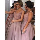 Three women in matching pink dresses pose for a selfie. Their dresses have glittery bodices and flowing skirts, creating an elegant, joyful atmosphere.