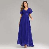Woman in a flowing royal blue gown with short flutter sleeves. The dress features a V-neck and a satin waistband, evoking elegance and grace.