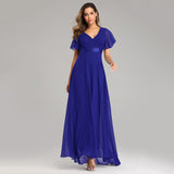 Woman in a flowing royal blue gown with short flutter sleeves. The dress features a V-neck and a satin waistband, evoking elegance and grace.