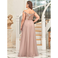 Woman in an elegant off-shoulder, sequin-topped gown stands on marble floor by a curved staircase, exuding sophistication. A classical statue is nearby.
